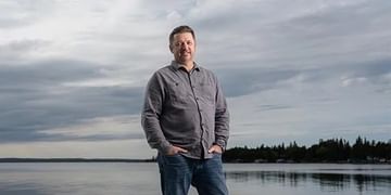 Wade standing on a river dock