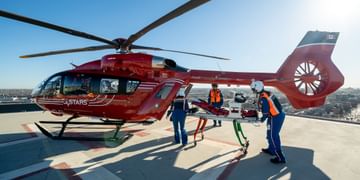 STARS air medical crew unload a stretcher from the back of a STARS air ambulance helicopter on top of the helipad at Winnipeg's Health Sciences Centre.