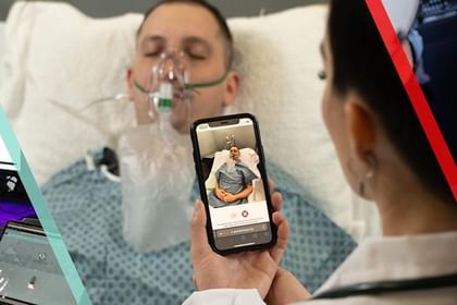 Person in hospital bed receiving oxygen treatment while others around them hold up smartphones to record or photograph the moment
