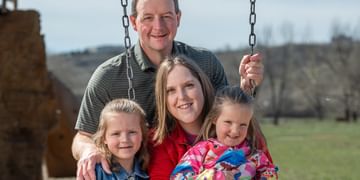 STARS Very Important Patient Kelly Waldron sits with her husband and daughters at a playground near their home.