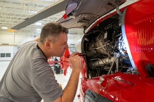 STARS Aircraft Maintenance Engineer Ryan Gillis inspects an engine with the access door open during a photo opportunity at the STARS Edmonton base.