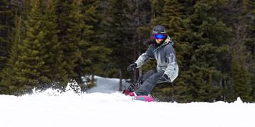 STARS Very Important Patient and Paralympic Snowboarding Athlete Michelle Salt snowboards on a winter day. Her prosthetic leg is shown.