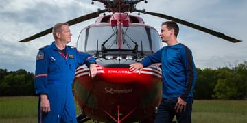 STARS Very Important Patient Brodie Richardson leans against the nose of a STARS BK117 air ambulance helicopter while talking to a member of STARS operations staff.