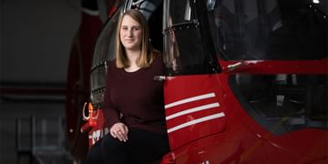 STARS Very Important Patient Christine Aarsby sits in the open side door of a STARS air ambulance helicopter during a visit to the closest STARS base.