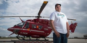 STARS Very Important Patient Cody Kerr stands in front of a STARS BK117 air ambulance helicopter in this older photo taken during his visit to a STARS base.