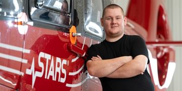 STARS Very Important Patient Dawson Mollenbeck poses alongside a STARS air ambulance helicopter.