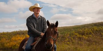 Kirk Wall sits in the saddle of his horse while riding on his property during a nice fall day.
