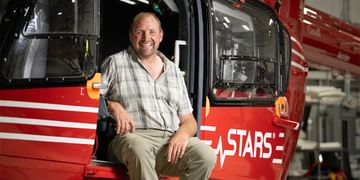 STARS Very Important Patient Sean Rickards sits in the side door of a STARS air ambulance helicopter during a visit to the closest STARS base.
