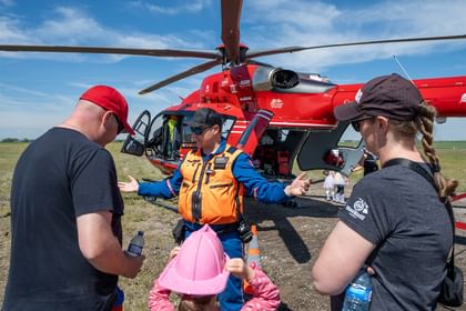 A STARS air medical crew member talks with a family during an event in a Southern Alberta community that had the helicopter land and be made available for display.