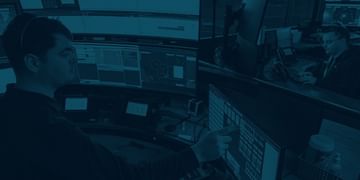 Overhead view of people working at computer workstations in a modern office environment, tinted in blue tones