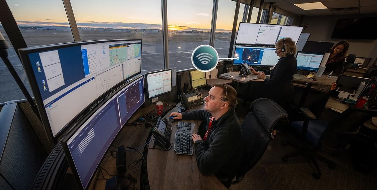 STARS Vigilant Emergency Communications Specialists working at their workstations in the Emergency Communications Centre. Through the window, the sun rises over the airfield.