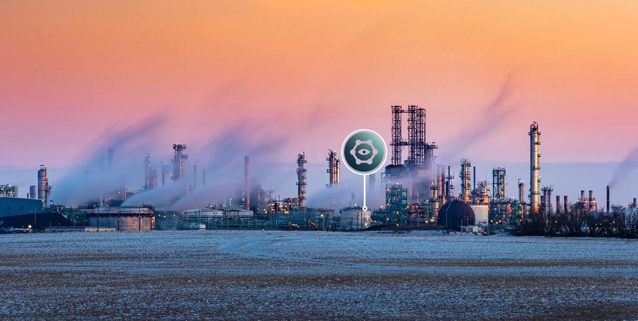 An oil and gas refinery pictured on a cool morning as the sun rises, lots of steam emitting from the stacks. A Vigilant Site Registration icon is superimposed above the location.