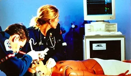 Two STARS crew work on a human patient simulator in a simulation environment.