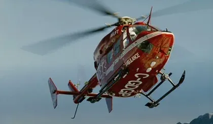 A STARS BK117 photo comes in to land at a mountain location.