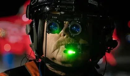 A STARS pilot wears and demonstrates a pair of night vision goggles that allow the crew to fly 24/7.