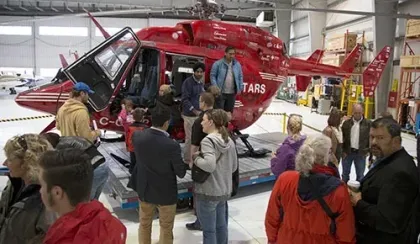 A group of people surround a STARS helicopter in 2015 celebrating the organizations 30th anniversary.