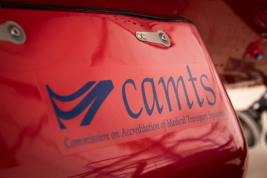 The Commission on Accreditation of Medical Transport Systems organization logo (in blue) as a decal applied to the side of a STARS helicopter air ambulance.