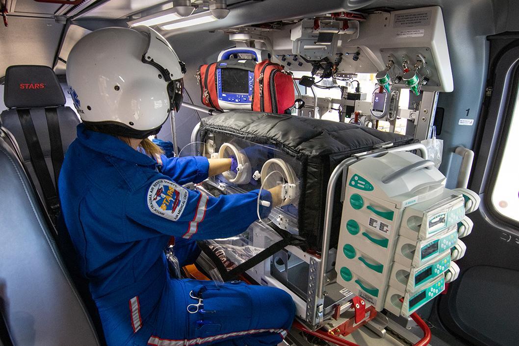 A STARS air medical crew member tends to a patient in the NICU isolette in this STARS file photo.