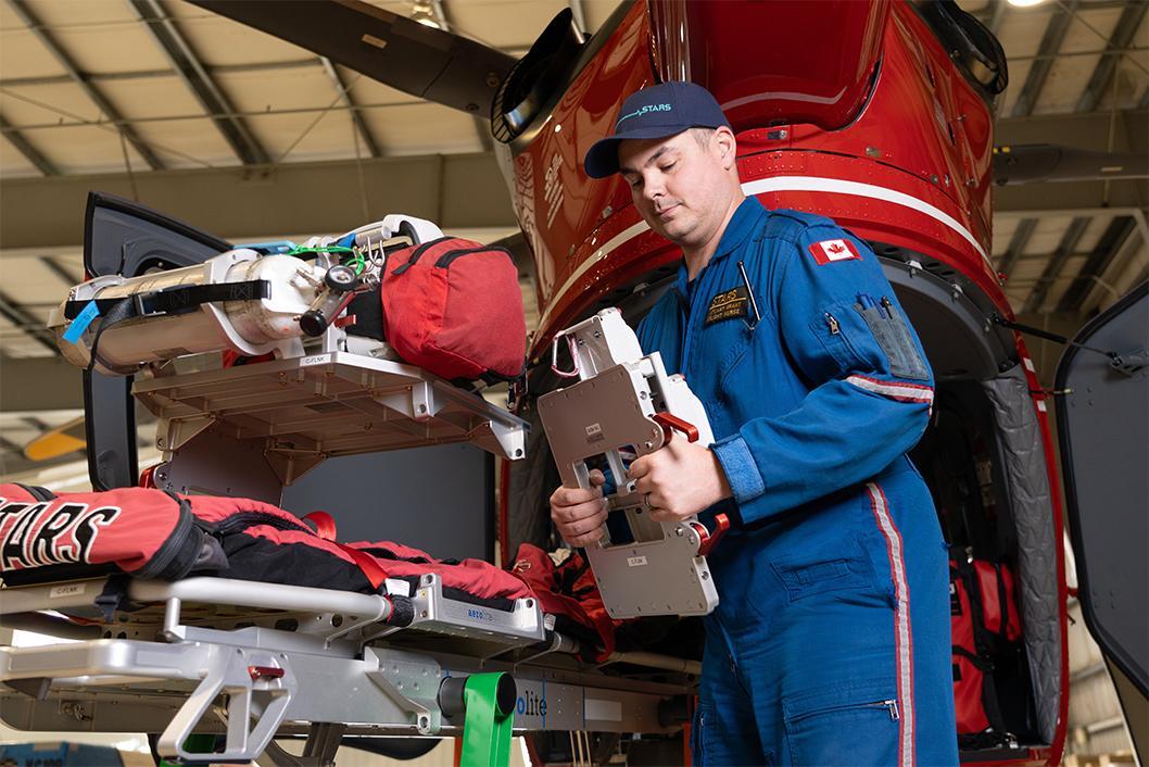 STARS flight nurse Stuart Grant demonstrates the innovative use of the stretcher pack rack that goes on every STARS mission.