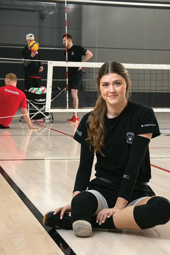 STARS Very Important Patient and Canadian National Sitting Volleyball team member and bronze medalist Jennifer Oakes poses for a photo during practice, teammates pictured in the background.