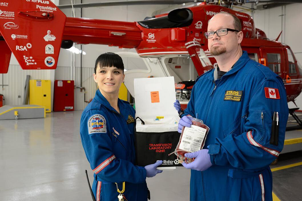STARS air medical crew staff hold a cooler bag that's used to transport blood products on STARS missions in a photo from 2013.