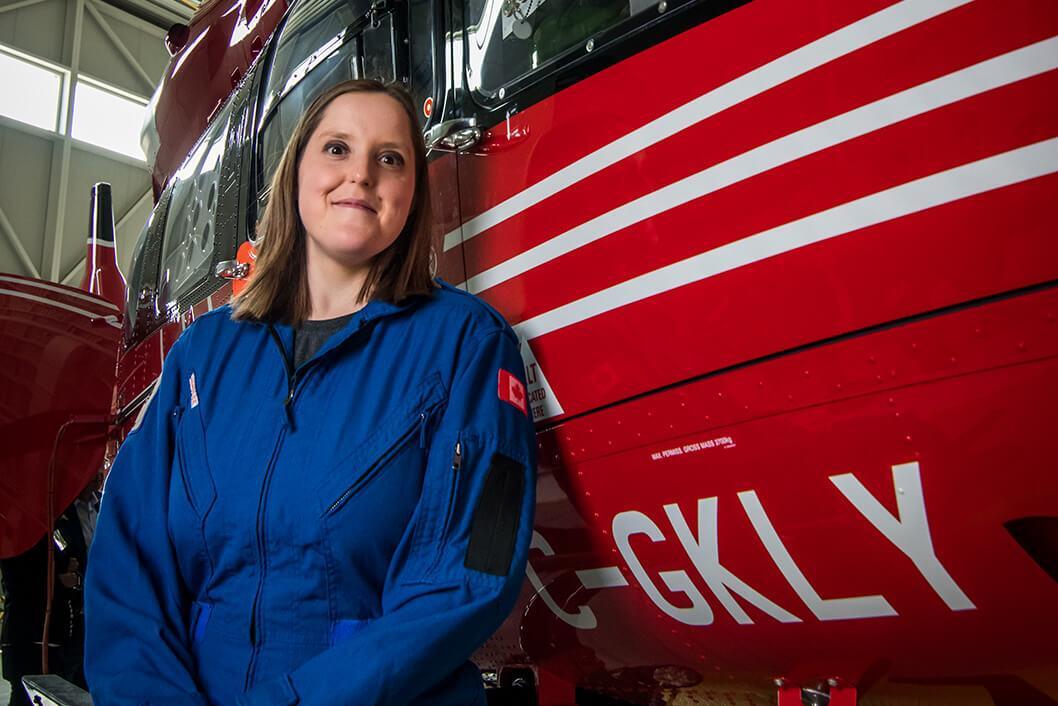 STARS' first Very Important Patient Kelly Waldron poses in a STARS blue suit alongside the STARS air ambulance bearing the call sign C-GKLY, named in her honour.
