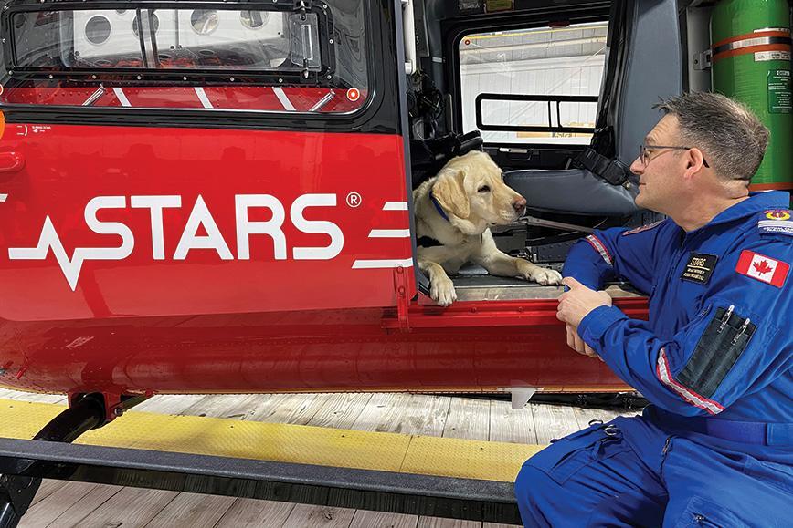 Orion sits inside the side door of a STARS air ambulance, listening to his primary caregiver Grant Therrien.