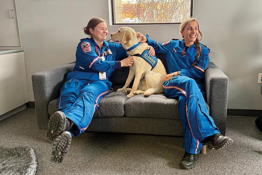 Orion sits with flight nurses Karen Oke (left) and Andrea Rajotte at the Winnipeg STARS base.