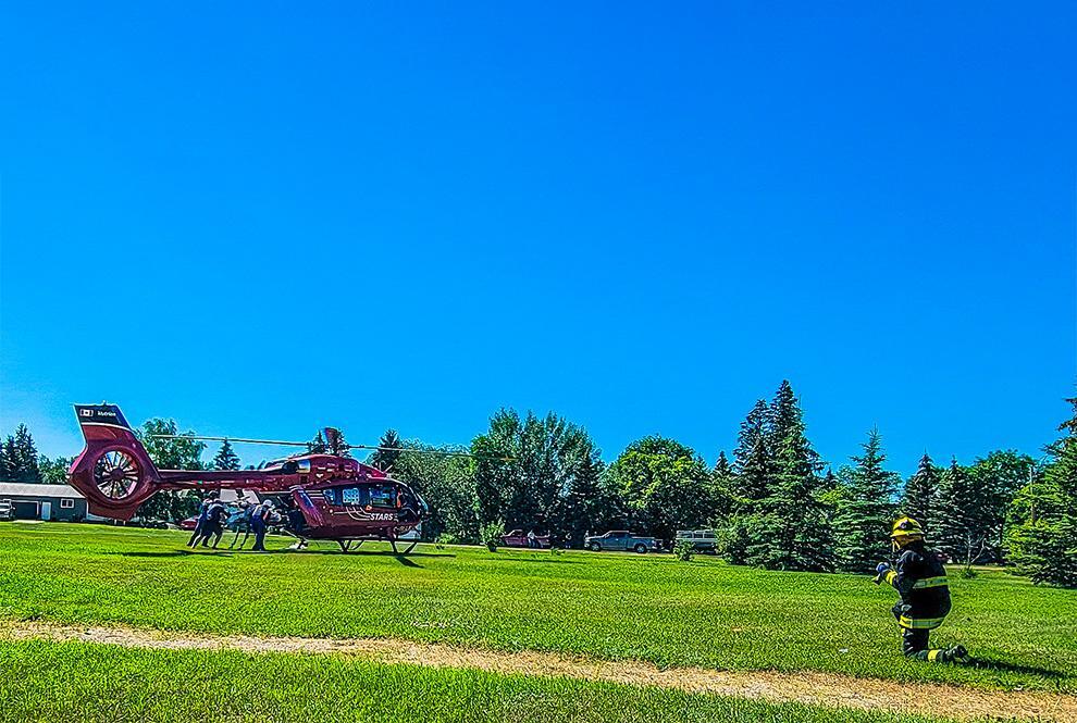 A long distance photo provided by paramedic Gil Maraboto of STARS crew loading Draidyn into the back of the STARS air ambulance from the scene of the incident. A firefighter waits to assist in the Landing Zone.